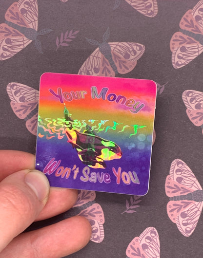 rainbow sticker with big whale and little whale in the water with the words your money won't save you around them the waves in the middle of the sticker are holographic